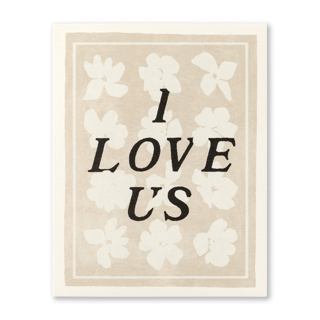 Anniversary Greeting Card - I Love Us! Illustration shows typography over a cream and white floral background with border.
