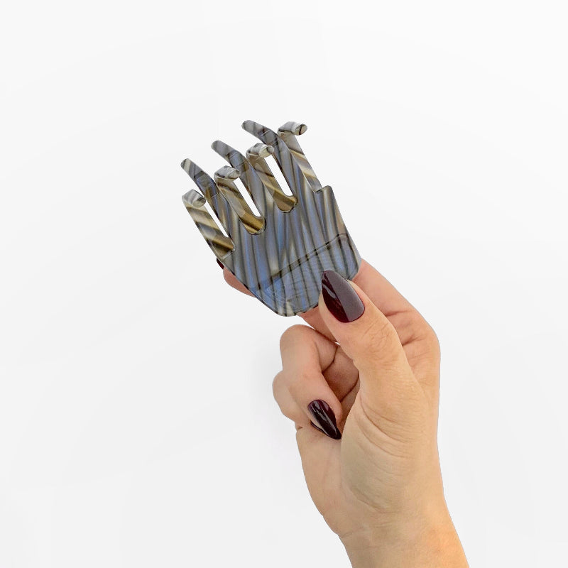 Hand holding Chunks Hair Claw Clip in Shadow on white background