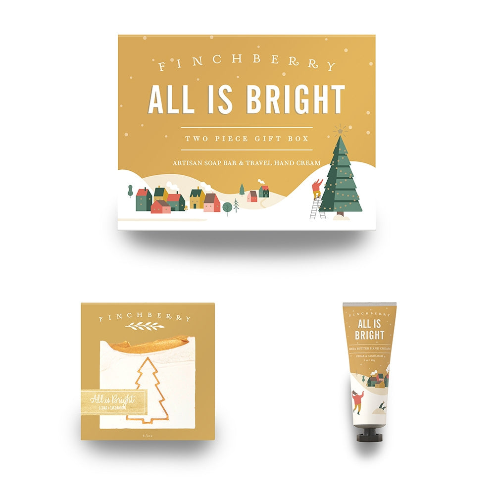 Finchberry All Is Bright Two Piece Gift Box. This Bath and Body Gift Set includes Handcrafted Vegan Soap and 1oz Hand Cream in Cedar and Cardamom. The packing is decorated with a winter holiday seasonal Christmas tree theme.