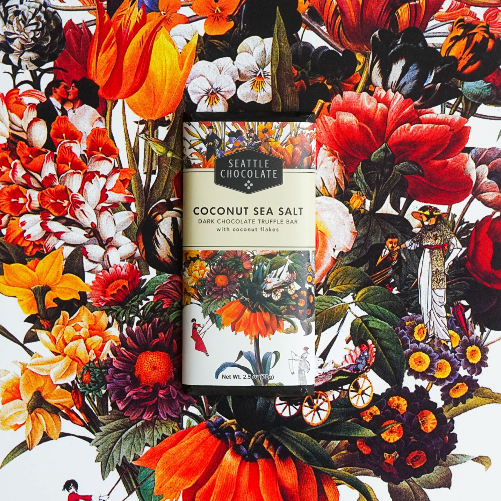Seattle Chocolate Coconut Sea Salt Dark Chocolate Truffle Bar with coconut flakes on floral background
