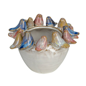 Ceramic planter pot with colorful birds around the rim in blues, reds, and yellows on a white base.
