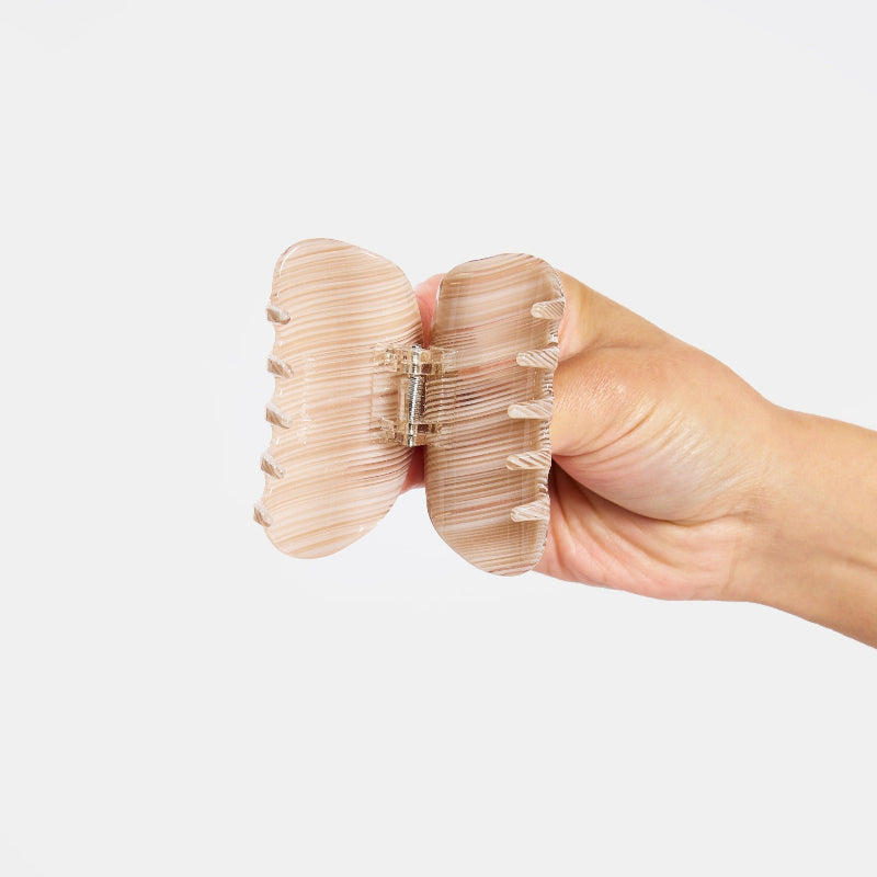 Hand holding Juno Hair Claw Clip in Oak open on a white background