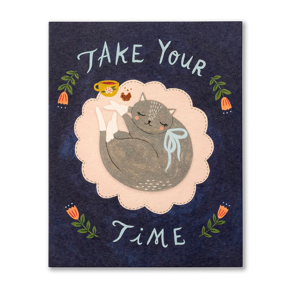 Get Well Greeting Card - Take Your Time. Illustration shows a grey cat curled up sleeping next to a half eaten cookie and cup of tea on a rug. The background is dark blue with flowers around the typography.