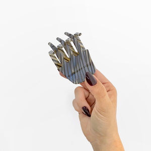 Hand holding Chunks Hair Claw Clip in Shadow on white background