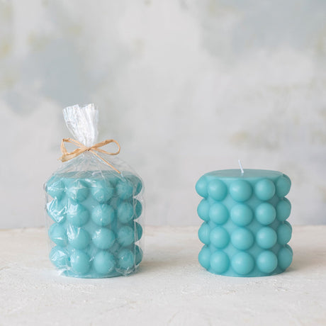 Unscented Hobnail Pillar Candle 4"H in Cyan Blue shown in cellophane packaging and without