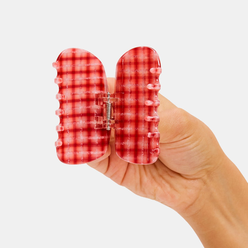 Hand holding Chunks Juno Hair Claw Clip in Red Plaid open on a white background