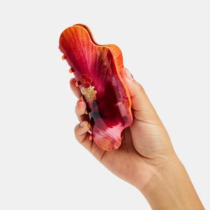 Hand holding Chunks Nimbus Hair Claw Clip in Hibiscus Flower on a white background