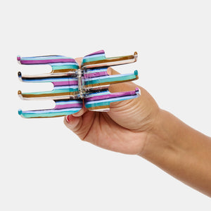 Hand holding Chunks Ursa Hair Claw in Frances open on a white background