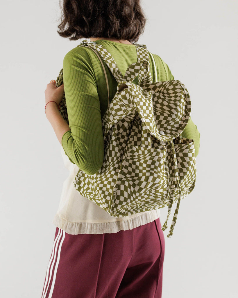 A model is shown with the Baggu Moss Trippy Checker Drawstring Backpack