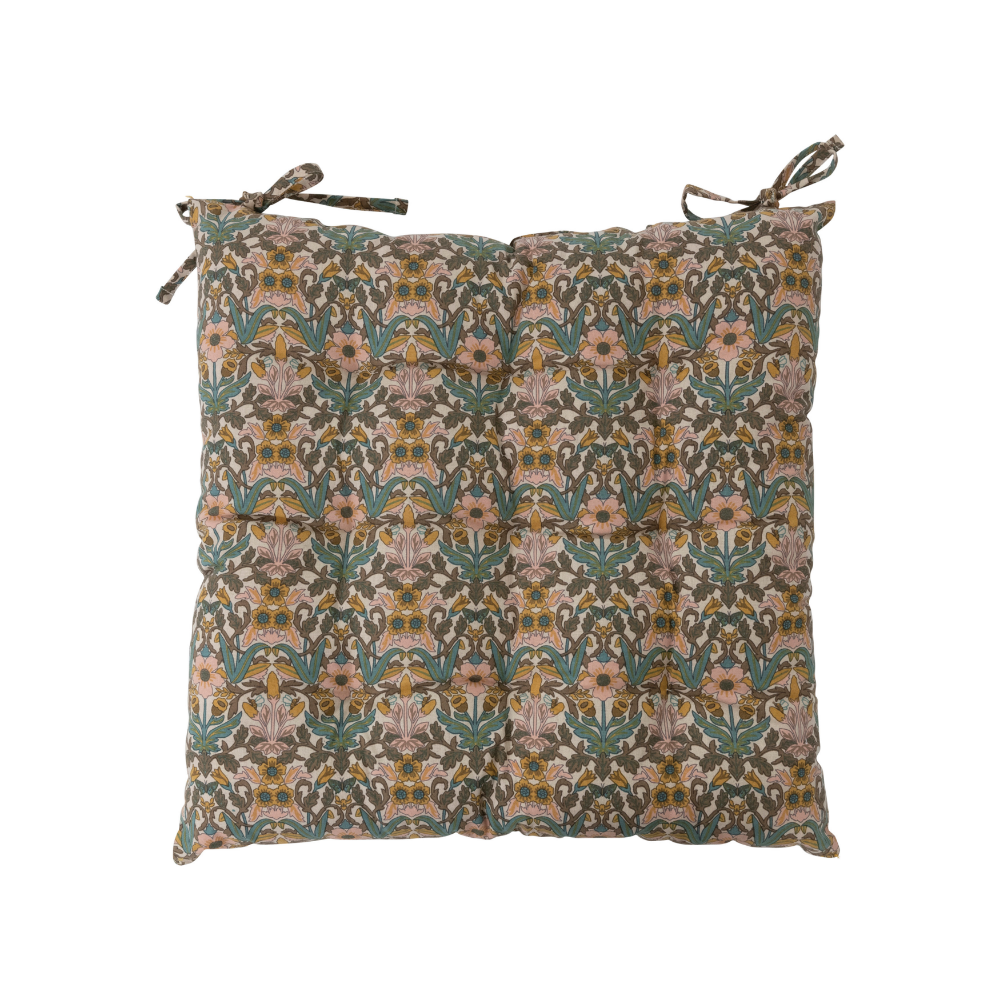 Square pillow cushion with a floral repeating pattern print. The pattern is muted tones of light pink, sage green, and a light mustard yellow. Two ties are on one side of the cushion to secure it to the back of a chair. The image has a plain white background.