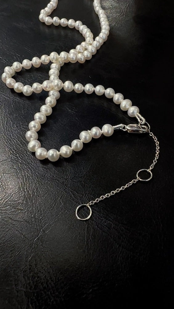 White Freshwater Pearls hand strung on silk cord with a sterling silver extension chain